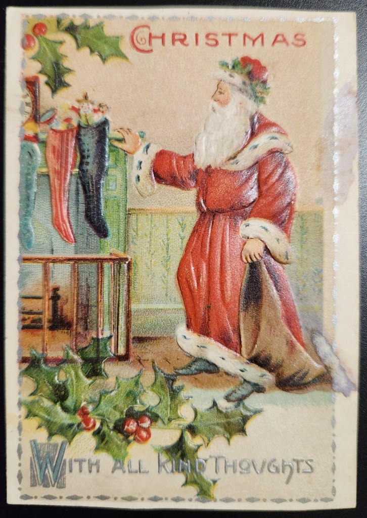 The front of an old Christmas card with the words Christmas with all kind thoughts and a picture of Santa Claus standing next to a fireplace where stockings are hanging. 