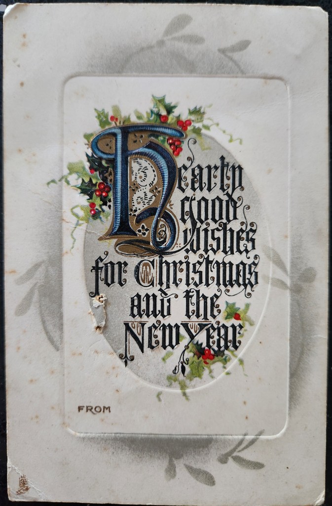 Photograph of a Christmas postcard from 1911 which says "Hearty good wishes for Christmas and the New Year"