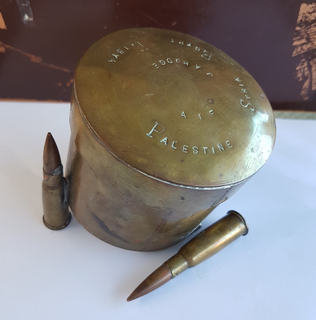 Photograph of a homemade metal container using three WWI bullet cases as feet
